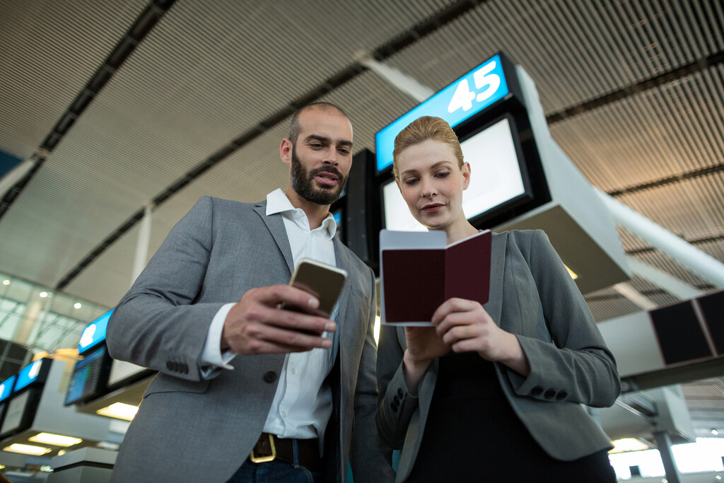 business people holding boarding pass using mobile phone - Boarding Pass Scanner Software 12 staff looking at boarding pass scanner software on mobile
