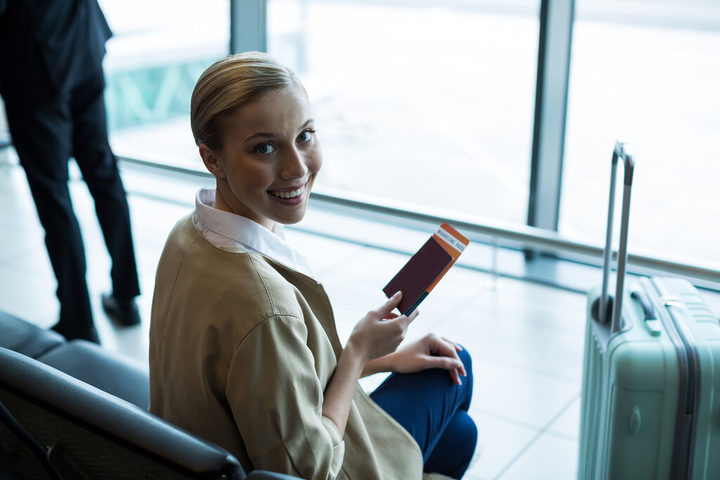 portrait female commuter with passport boarding pass waiting area - Airport Check-In Software 11 airport check-in software document processing