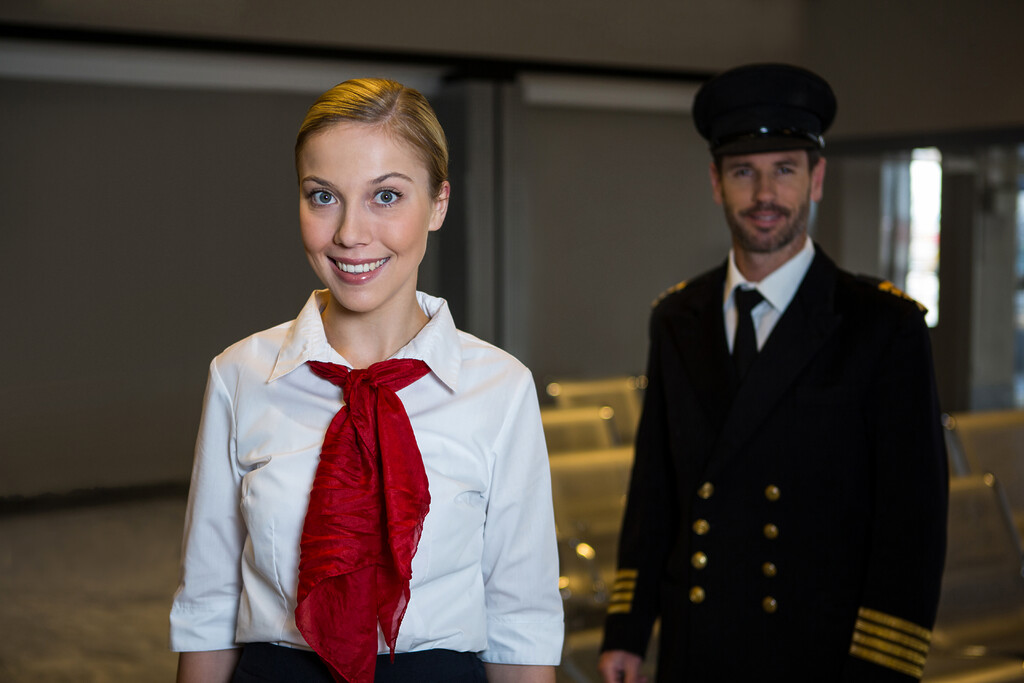 happy pilot air hostess standing airport terminal - Aviation AI Development Services 9 Pilot and cabin crew member in an airport terminal
