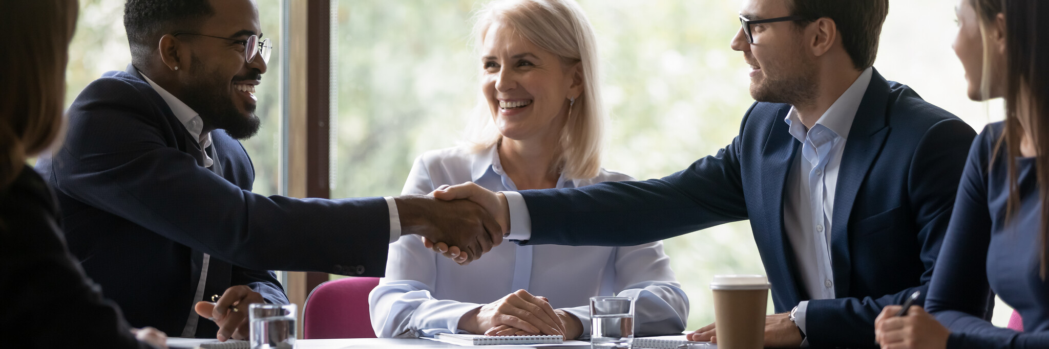 istock 1268659490 - Custom Insurance Software Development Company 1 Colleagues in business attire shaking hands and smiling